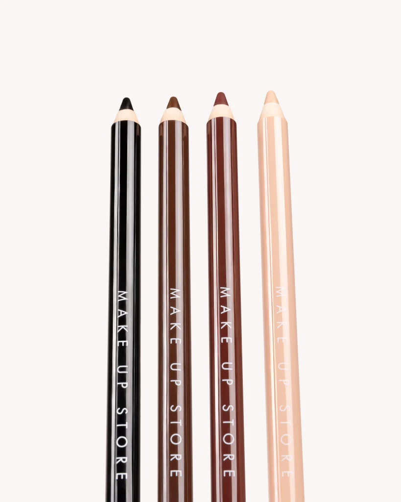 Symmetrisk närbild av fyra sminkpennor från Make Up Store i nyanser från svart till beige. En ren och minimalistisk produktbild som framhäver förpackningsdesign och färgskala.