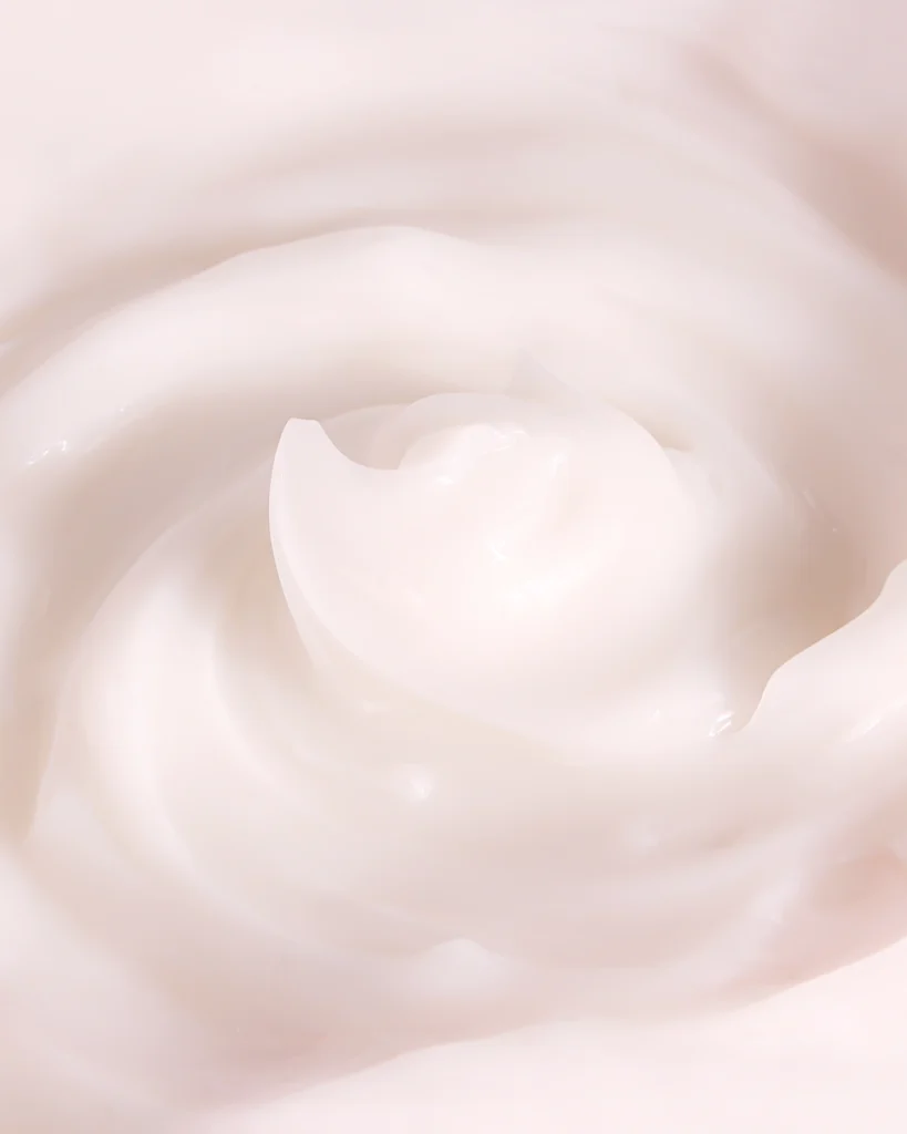 Professionellt texturfoto av formulan till Ida Warg Beauty hårinpackning. Närbilden visar en rik, krämig och ljusrosa textur virvlad som en ros, perfekt som inspiration för en portfolio inom beauty och skönhetsfotografering. Skapad av en produktfotograf i Stockholm.