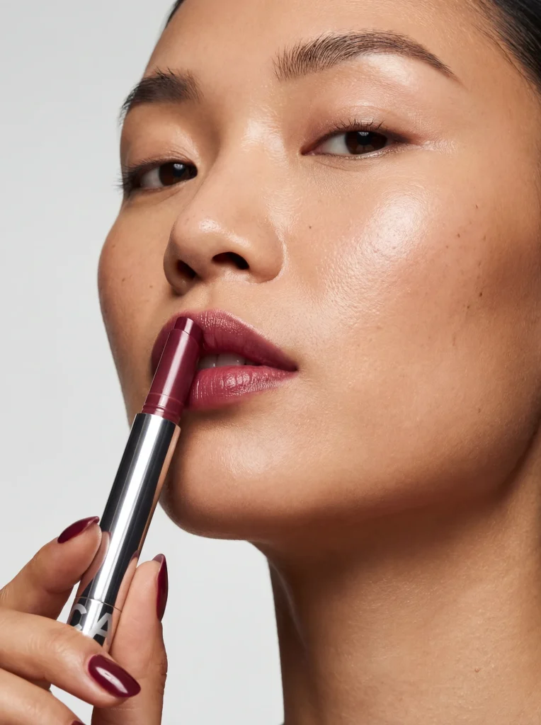 AI-genererad editorial-bild på en modell som visar ett CAIA lip balm, skapad för mode- och kosmetikamagasin.