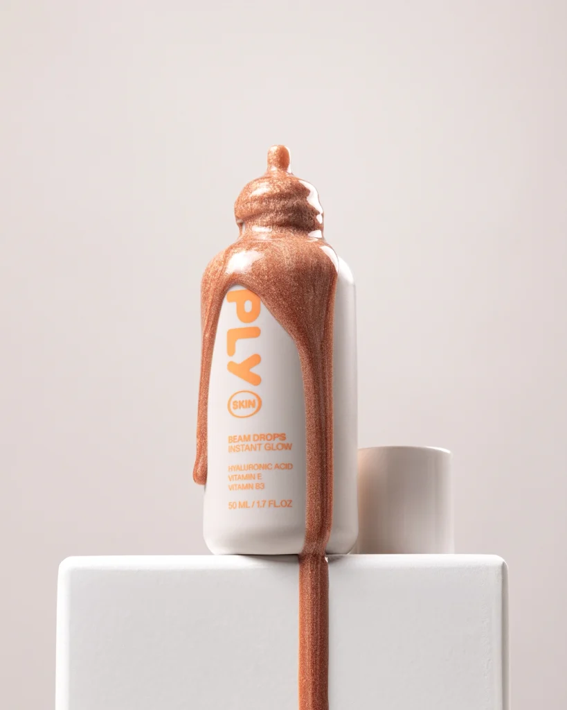 Minimalistiskt produktfoto av Ply Skin Beam Drops mot en varm, gyllene bakgrund. Ljussättningen lyfter fram flaskans reflektioner och produktens lyster. Högkvalitativt content för skönhetsvarumärken och digital marknadsföring.